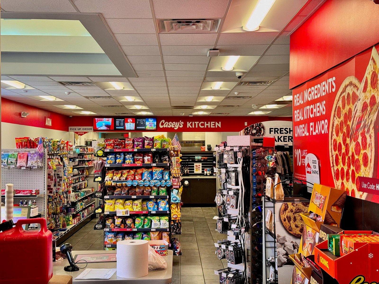 Casey's便利店内部实景，田纳西州Farragut门店，可见"Casey's Kitchen"厨房区招牌、零食货架、披萨宣传海报及ATM机